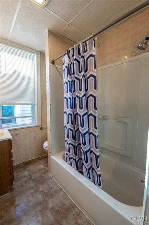 full bathroom featuring shower / bath combo, tile walls, vanity, and toilet