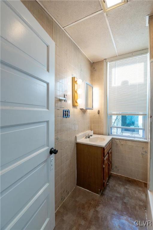 bathroom with vanity and tile walls