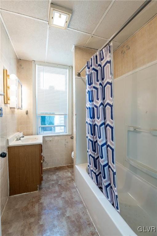 full bathroom with tile walls, vanity, shower / bath combination with curtain, and toilet