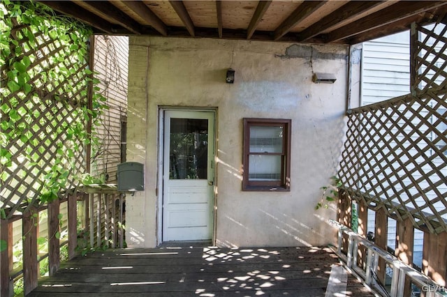 view of exterior entry featuring a wooden deck