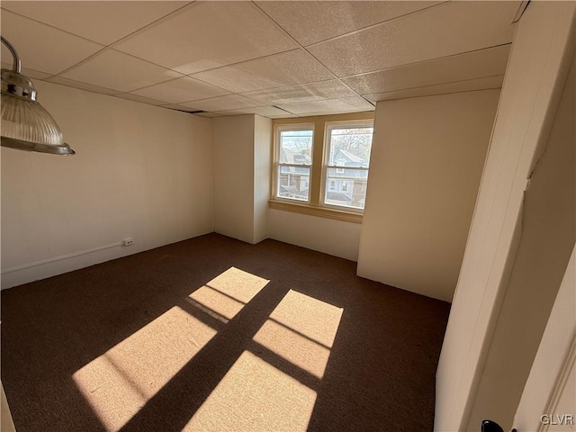 carpeted spare room featuring a paneled ceiling