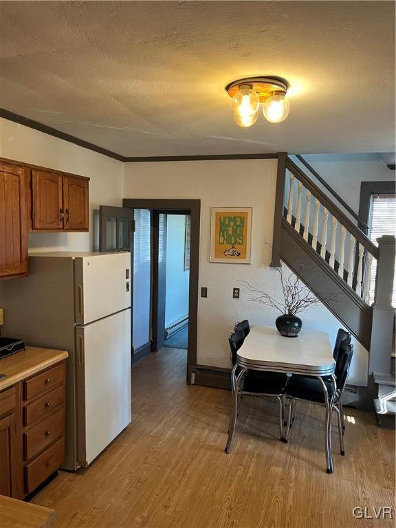 162 S Union St, Easton, PA 18042 - kitchen with brown cabinets, wood finished floors, freestanding refrigerator, a textured ceiling, and light countertops