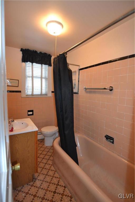 162 S Union St, Easton, PA 18042 - bathroom featuring a baseboard radiator, vanity, shower / bath combo with shower curtain, tile walls, and tile patterned floors