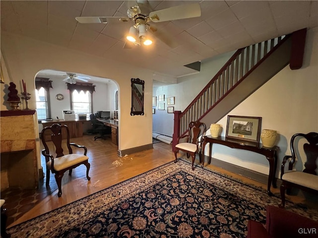 162 S Union St, Easton, PA 18042 - living area with a ceiling fan, arched walkways, wood finished floors, a baseboard heating unit, and stairway