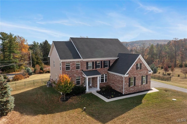 view of front of house featuring a front lawn and central air condition unit