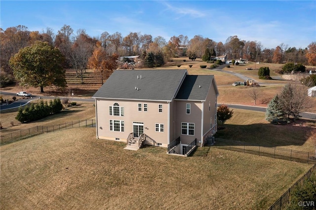 rear view of property featuring cooling unit and a yard