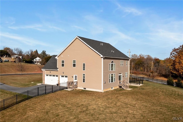 rear view of house featuring a garage and a yard