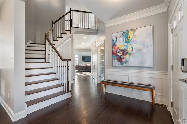 foyer featuring a high ceiling, dark hardwood / wood-style flooring, and ornamental molding