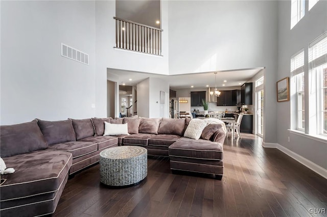 living room featuring dark wood-type flooring and a towering ceiling