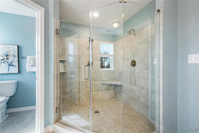 bathroom with tile patterned floors, toilet, and a shower with shower door