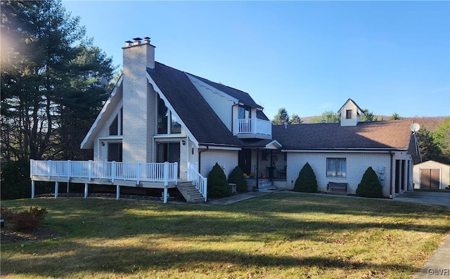 view of front of house with a wooden deck, a balcony, a front lawn, and a shed