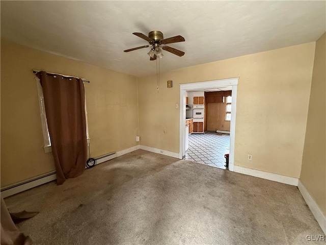 carpeted spare room with baseboards, ceiling fan, and a baseboard radiator