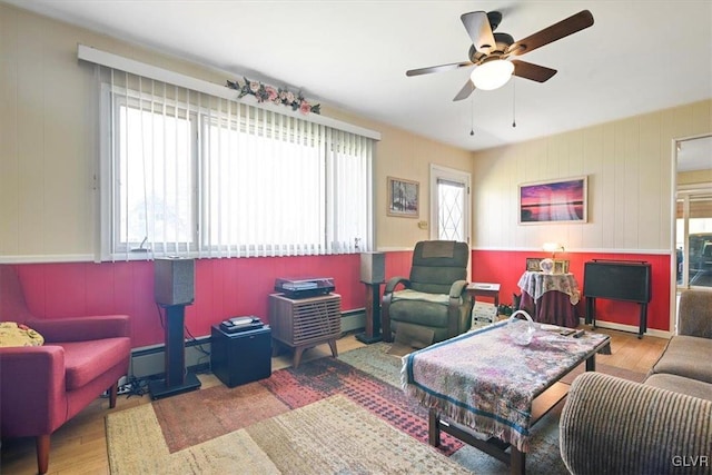 living room with a wealth of natural light, wood-type flooring, and ceiling fan