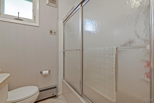 full bathroom featuring toilet, wooden walls, baseboard heating, and enclosed tub / shower combo