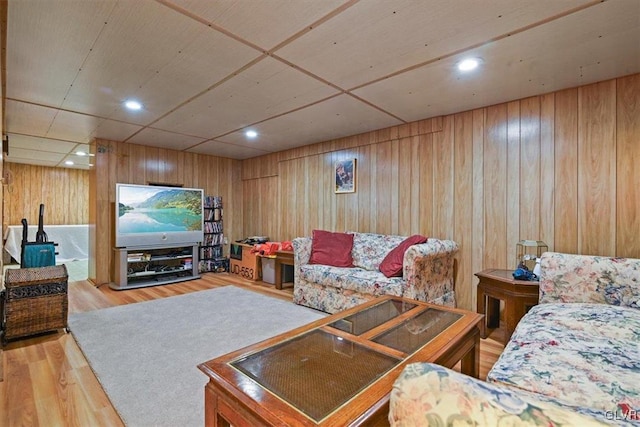 living room with light hardwood / wood-style floors and wooden walls