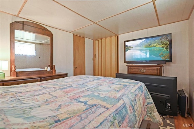 bedroom featuring hardwood / wood-style floors and wooden walls