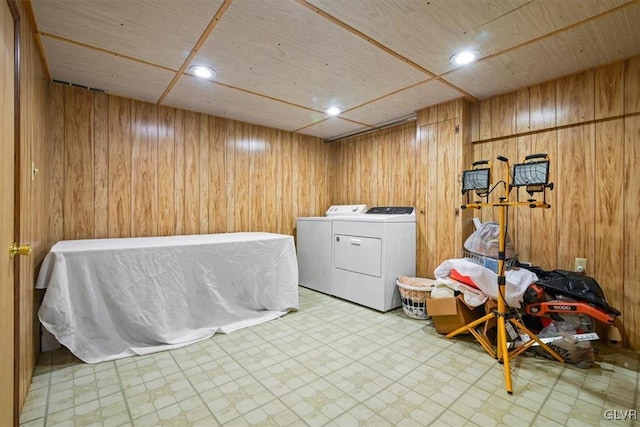 washroom with washer and dryer and wooden walls