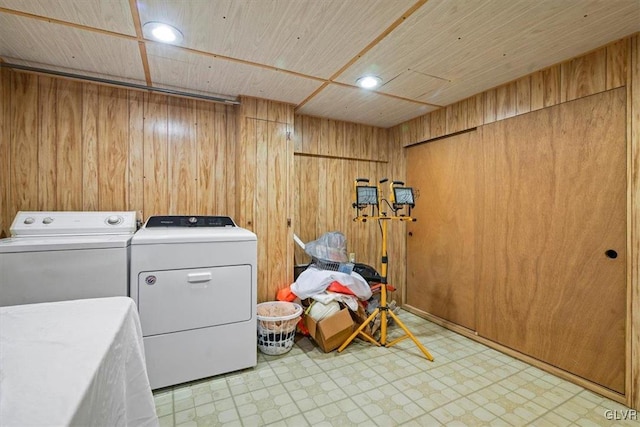 laundry area featuring wooden ceiling, washing machine and dryer, and wooden walls