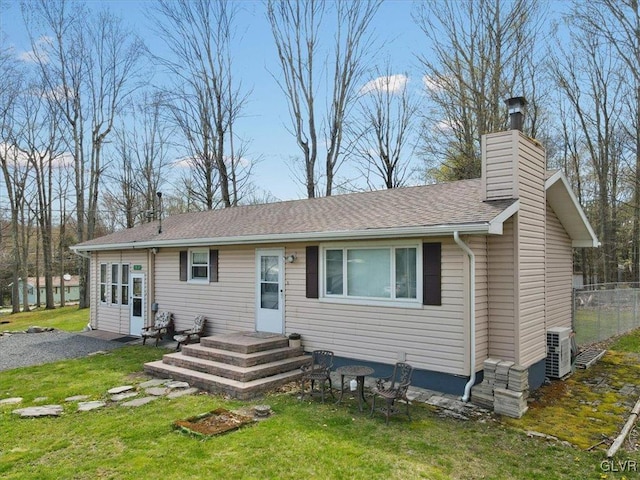 exterior space featuring central AC unit and a front lawn