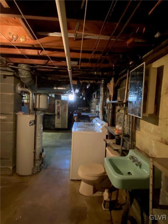 basement featuring water heater, sink, and washer / clothes dryer