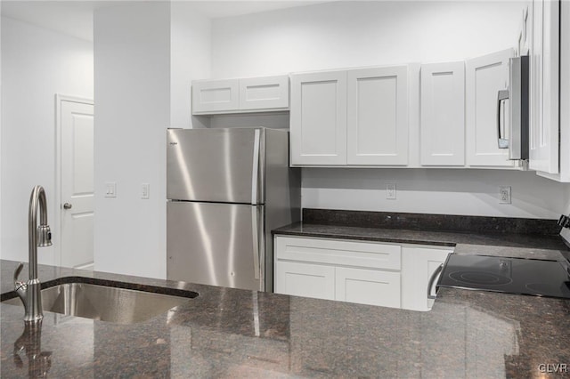 kitchen with white cabinets, dark stone counters, sink, and appliances with stainless steel finishes