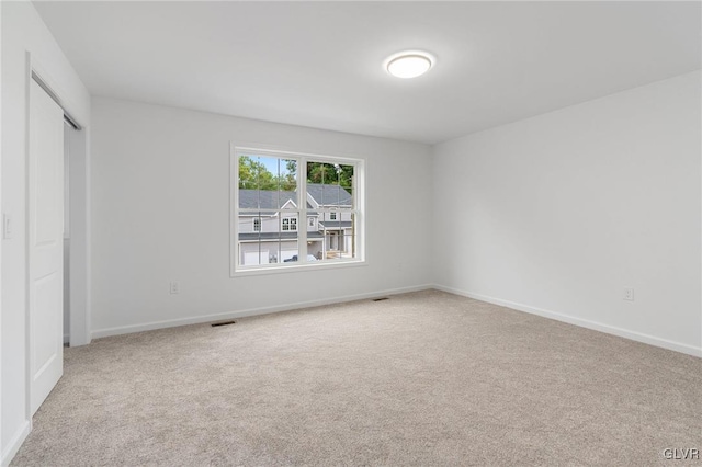 unfurnished bedroom featuring a closet and light carpet