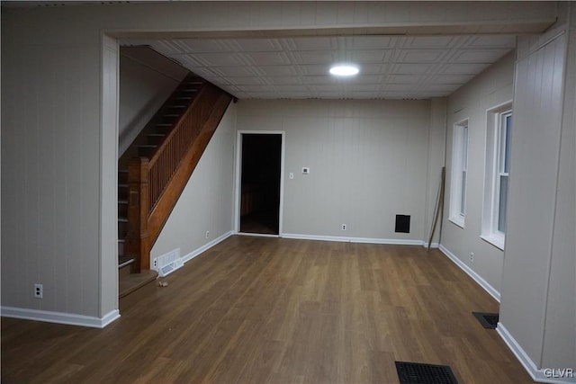 empty room featuring wood-type flooring and wooden walls