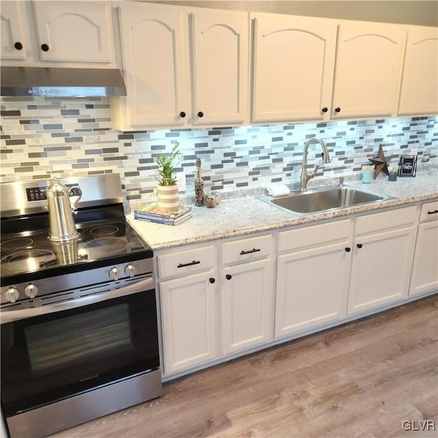 kitchen featuring range hood, sink, light hardwood / wood-style floors, white cabinets, and stainless steel range oven