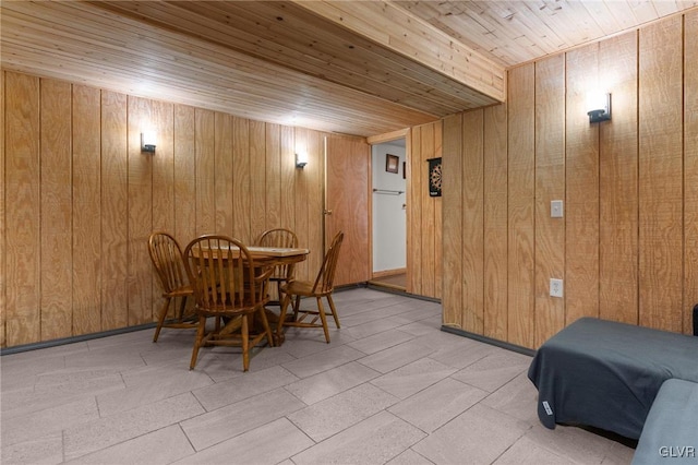 dining space with wood ceiling and wooden walls