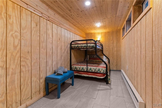 bedroom with a baseboard heating unit, wooden walls, and wooden ceiling