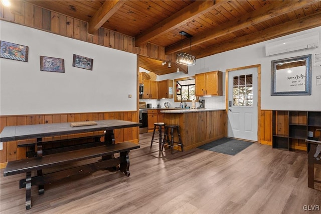 interior space featuring a wall mounted AC, beam ceiling, sink, light hardwood / wood-style flooring, and wood ceiling