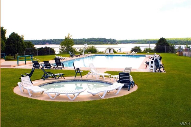 view of swimming pool featuring a water view and a yard