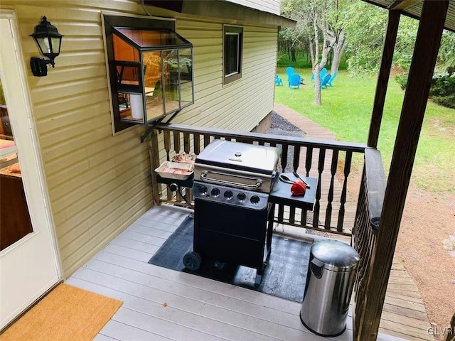 wooden deck featuring a yard and area for grilling