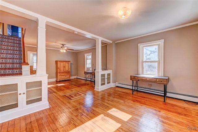 interior space with ceiling fan, baseboard heating, light wood-type flooring, and ornamental molding