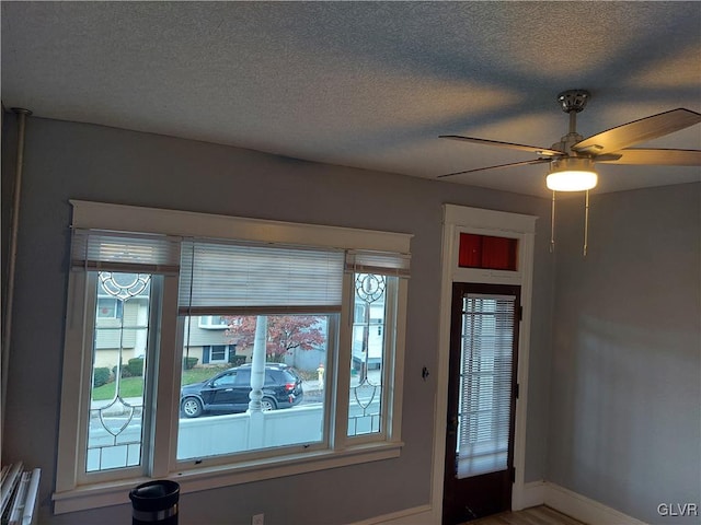 entryway with ceiling fan and a textured ceiling