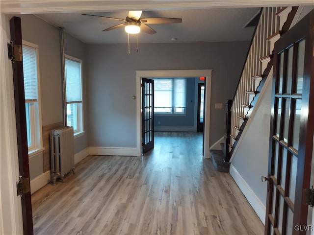 entryway featuring radiator, light wood-type flooring, french doors, and ceiling fan