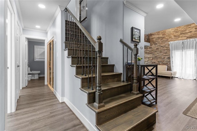 stairs featuring hardwood / wood-style flooring and crown molding