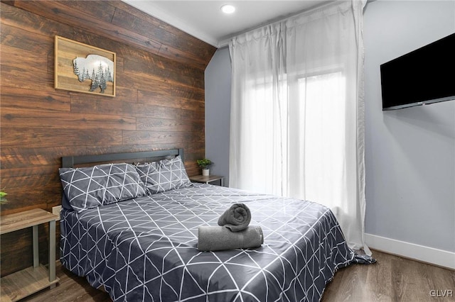 bedroom featuring hardwood / wood-style flooring and wooden walls