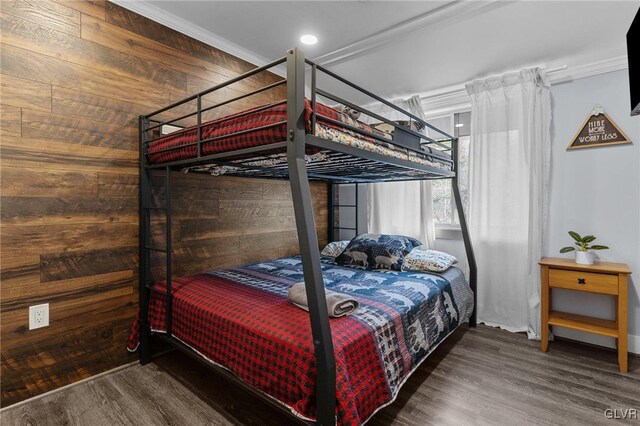 bedroom featuring dark wood-type flooring, crown molding, and wood walls