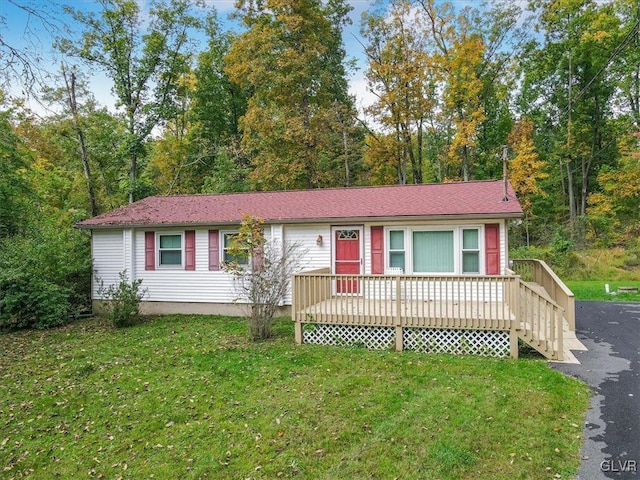 ranch-style house with a front lawn and a wooden deck