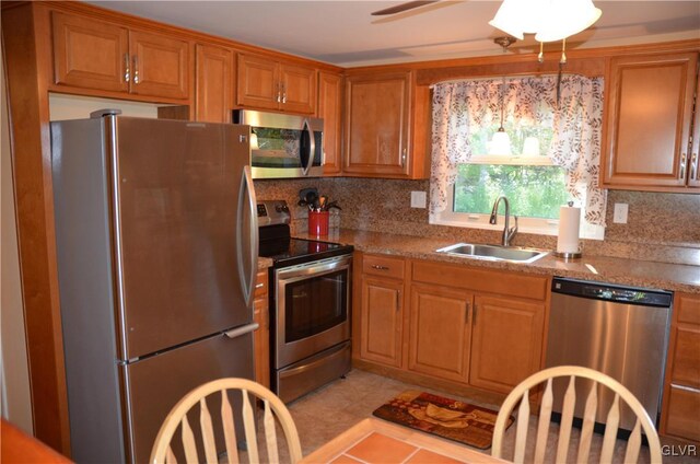 kitchen with appliances with stainless steel finishes, sink, backsplash, and light tile patterned floors