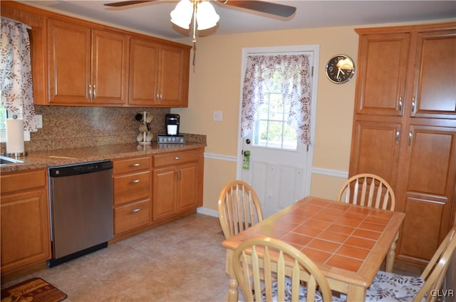 kitchen with decorative backsplash, light stone counters, stainless steel dishwasher, and ceiling fan