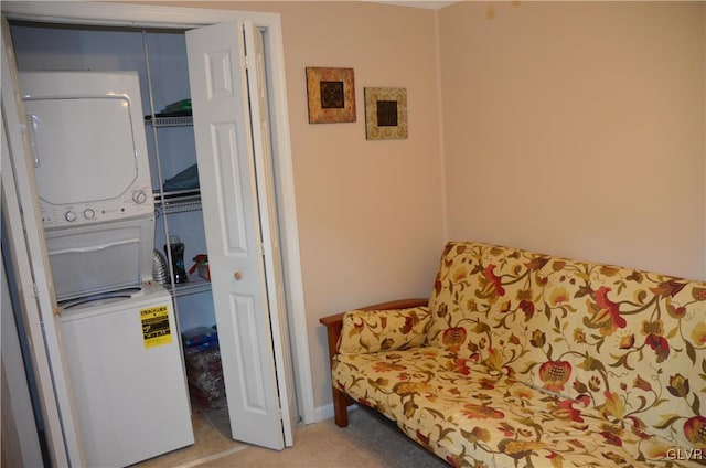 sitting room with stacked washer and clothes dryer