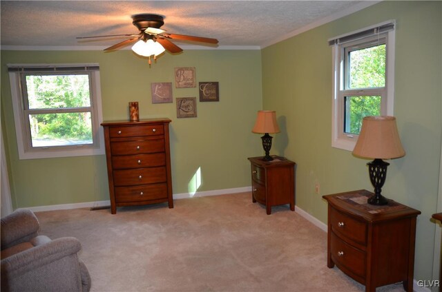 living area with ceiling fan, plenty of natural light, light carpet, and crown molding