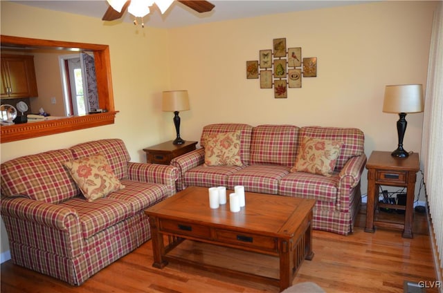 living room featuring visible vents, a ceiling fan, and light wood-type flooring