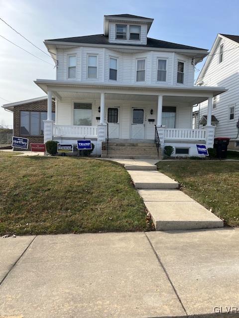 view of front facade with a front yard and covered porch