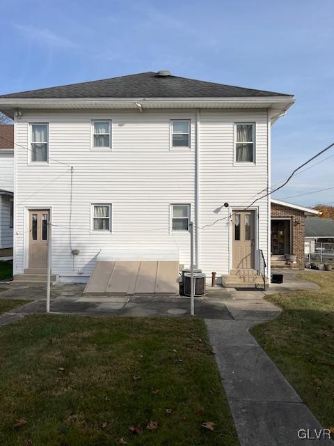 rear view of property with a yard