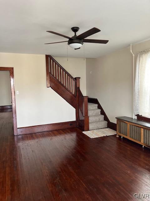 staircase featuring radiator heating unit, hardwood / wood-style flooring, and ceiling fan