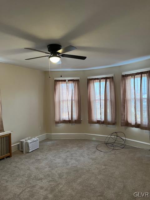 empty room with ceiling fan and carpet flooring