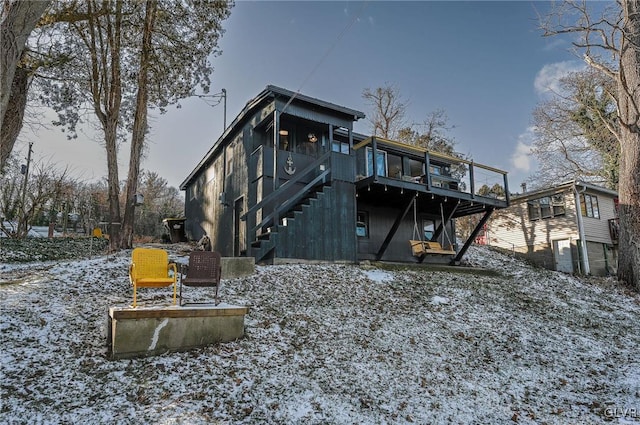 snow covered house featuring a deck